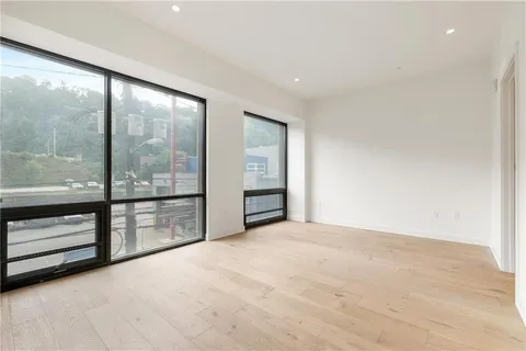 a roof deck with couches and wooden floor