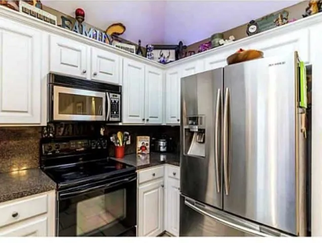 a kitchen with stainless steel appliances granite countertop a refrigerator a stove and a sink with dishwasher