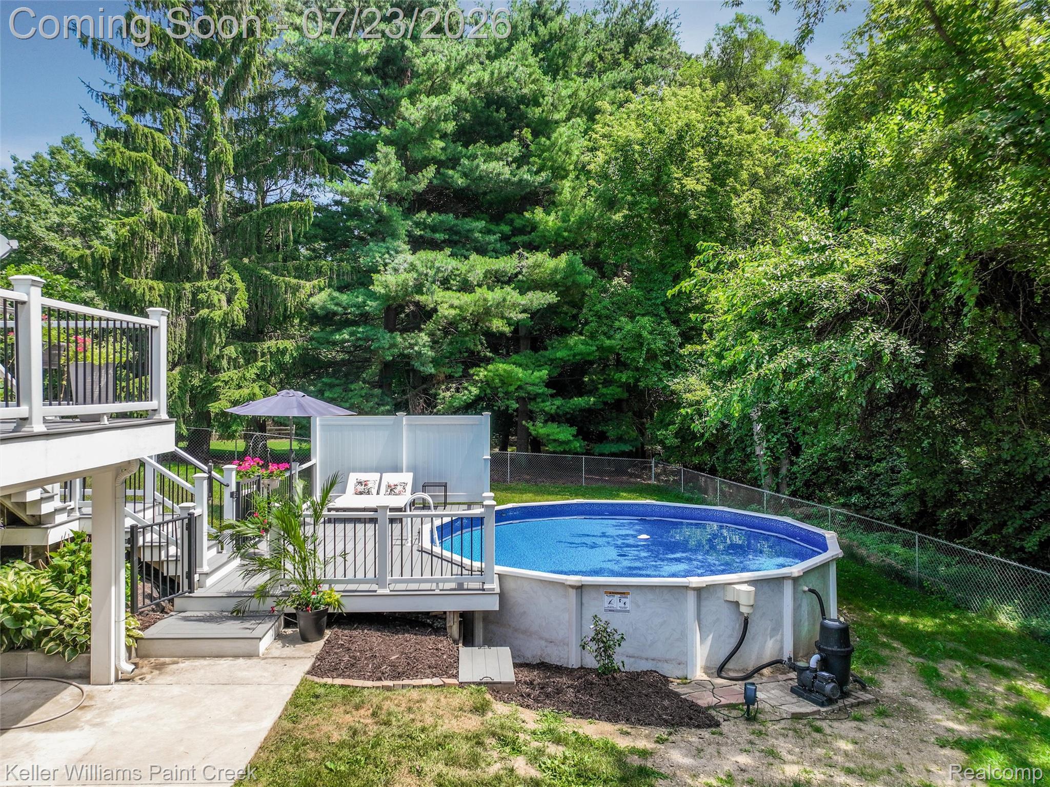 2611 Quail Run Street Rochester, MI 48306 - Photo 39 of 48 Elevated deck with white railings and black balusters, providing access to a ground-level deck featuring a round above-ground pool