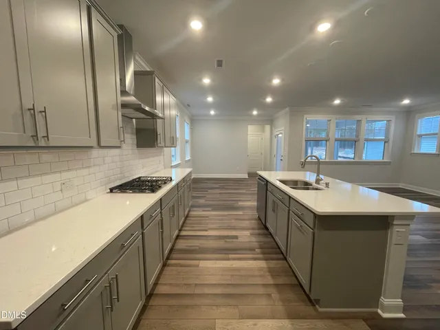 a view of kitchen with kitchen island wooden floor center island and stainless steel appliances