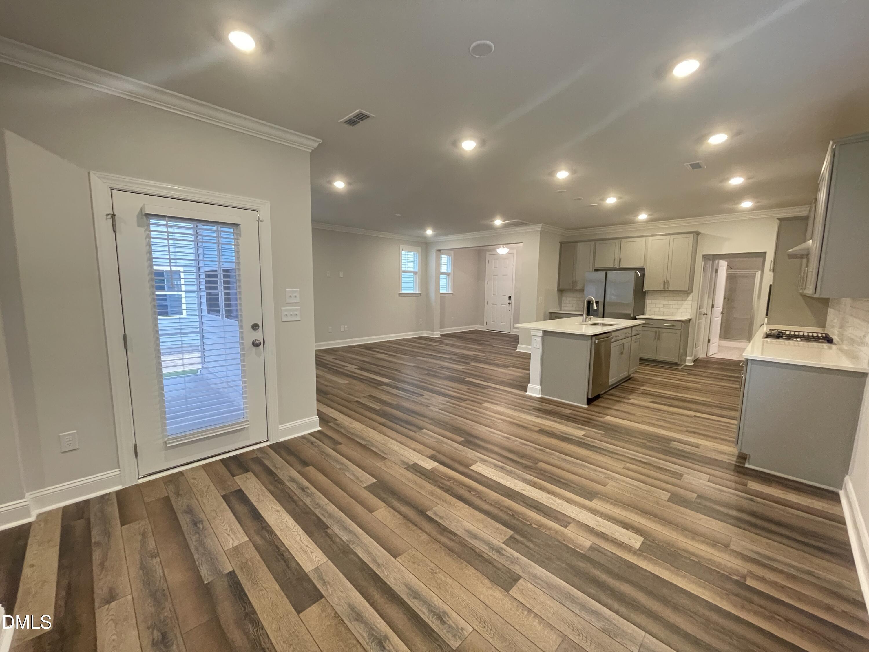 207 Edge Of Auburn Boulevard Raleigh, NC 27610 - Photo 7 of 32 a view of kitchen with kitchen island wooden floor center island and stainless steel appliances
