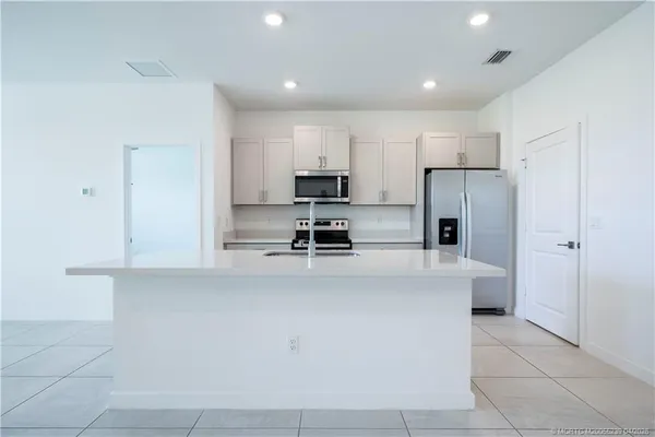 a kitchen with a refrigerator and a stove top oven
