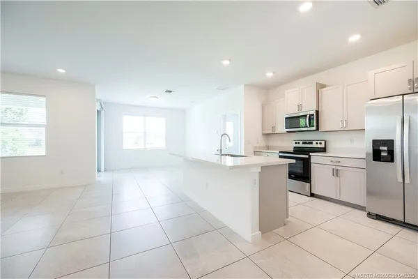 a kitchen with a refrigerator a sink and a stove top oven