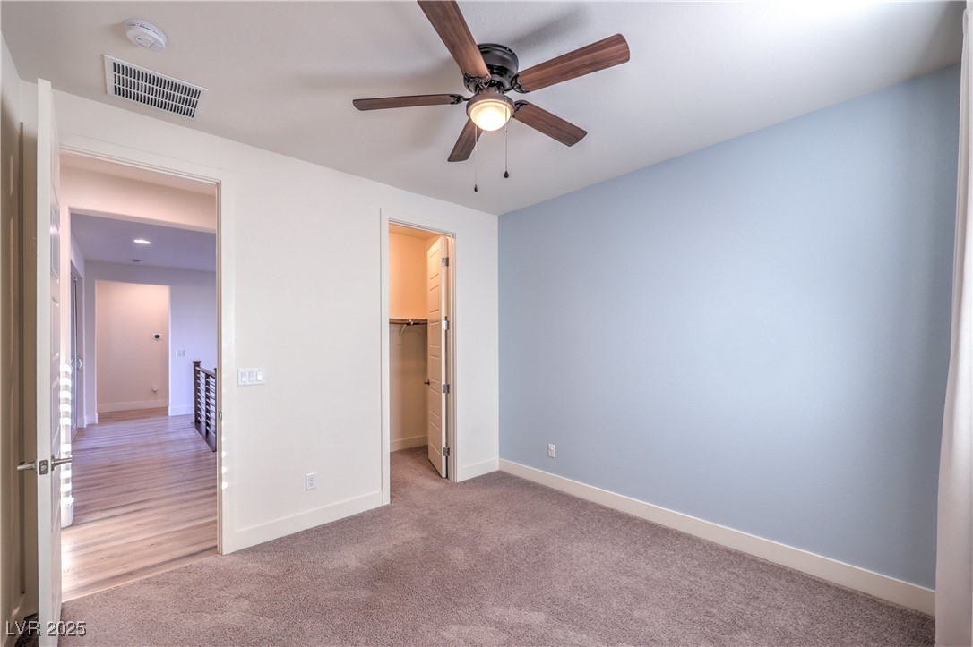 9655 Skye Star Avenue Las Vegas, NV 89166 - Photo 23 of 46 Unfurnished bedroom featuring carpet floors, a walk in closet, and ceiling fan