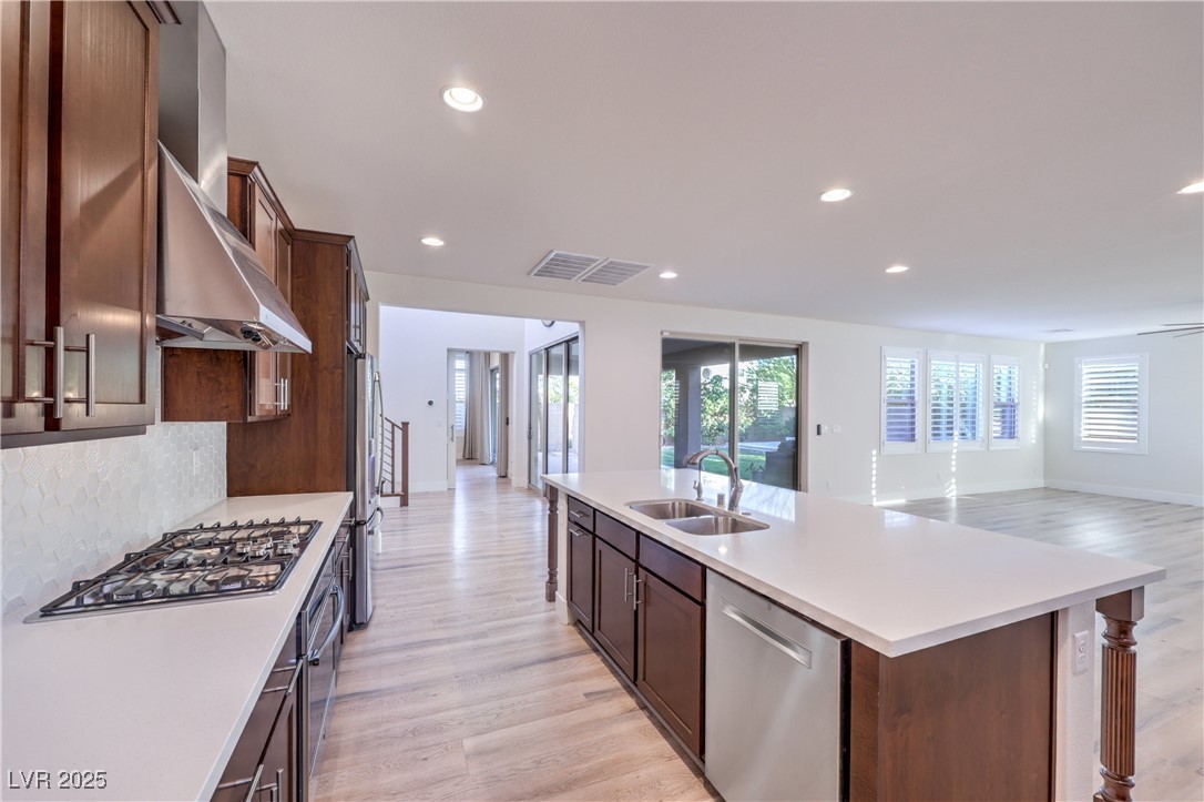 9655 Skye Star Avenue Las Vegas, NV 89166 - Photo 46 of 46 Kitchen featuring light wood-style floors, stainless steel appliances, recessed lighting, wall chimney exhaust hood, and open floor plan