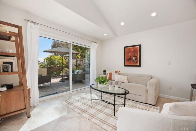 a living room with furniture and kitchen view