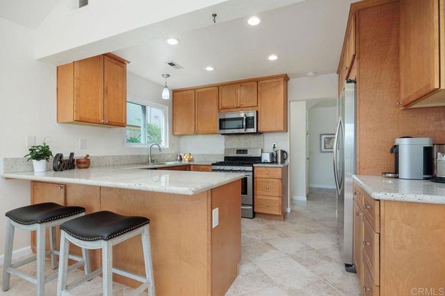 a kitchen with stainless steel appliances granite countertop a refrigerator stove and microwave