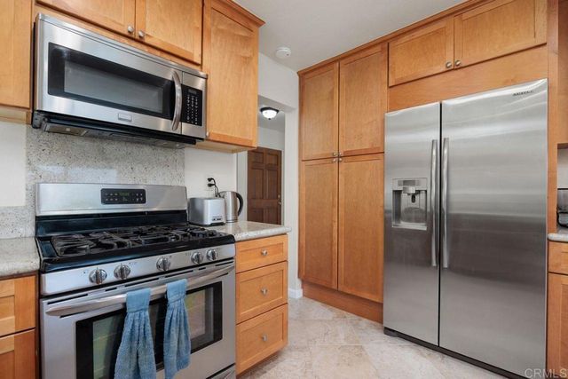 a kitchen with stainless steel appliances granite countertop a refrigerator and a sink