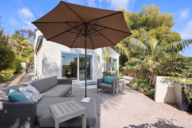a view of a house with backyard and sitting area
