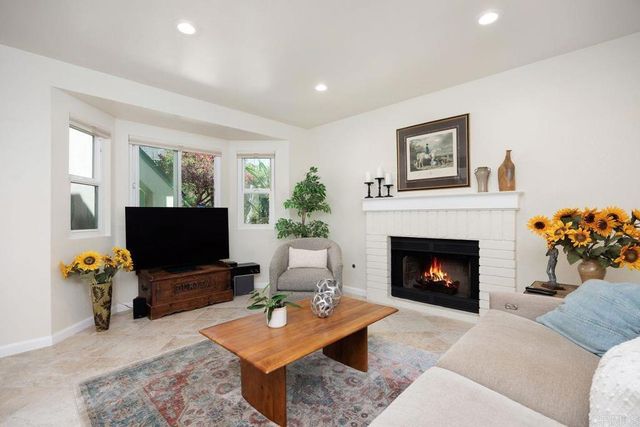 a living room with furniture a fireplace and a flat screen tv