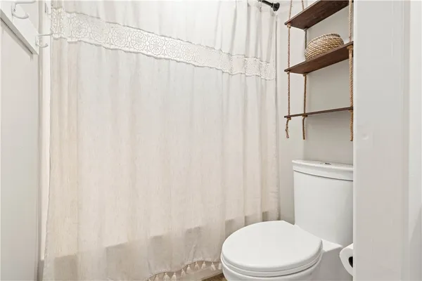 a white toilet sitting next to a shower