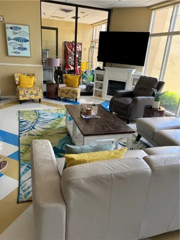 a living room with furniture a fireplace and a flat screen tv