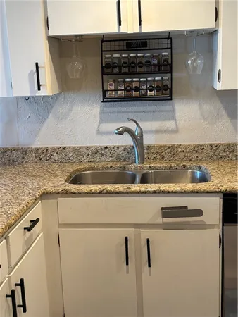 a kitchen with a sink a stove and cabinets