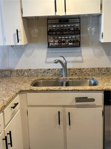 a kitchen with a sink a stove and cabinets