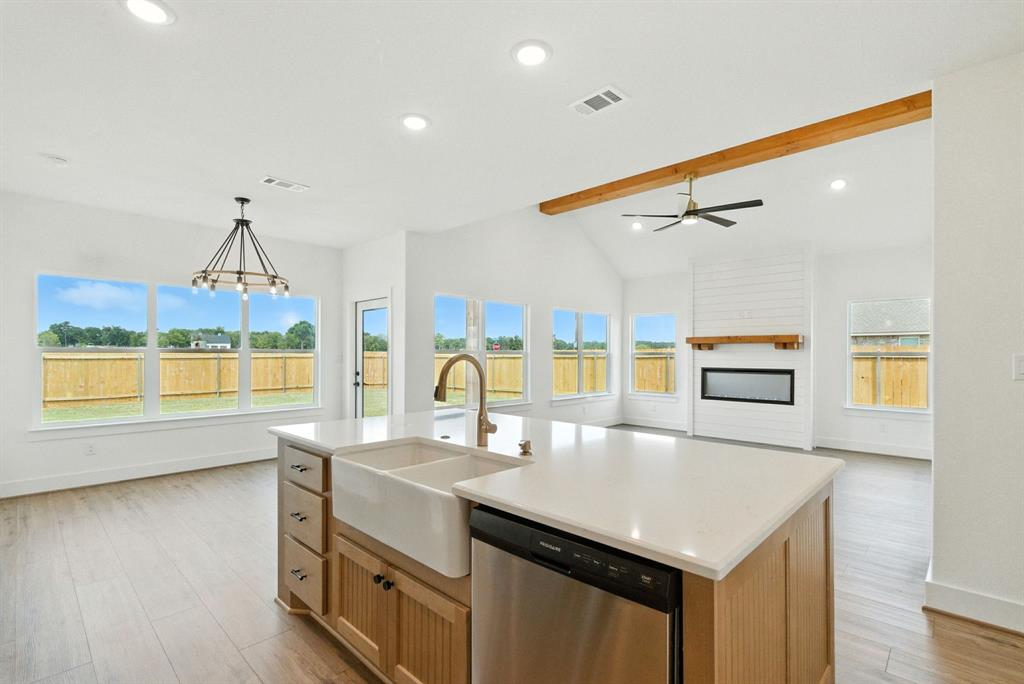 421 Jameson Springtown, TX 76082 - Photo 11 of 37 a kitchen with a stove a sink and a dining table with wooden floor