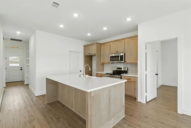 a kitchen with a sink stove and refrigerator