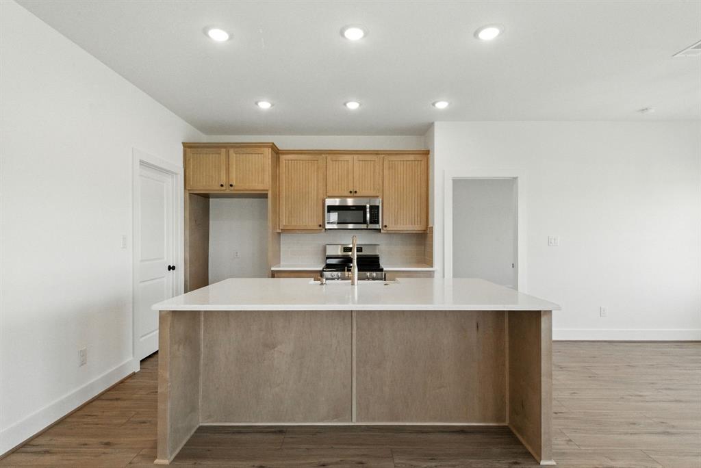 421 Jameson Springtown, TX 76082 - Photo 7 of 37 a large kitchen with kitchen island a stove a sink and a refrigerator