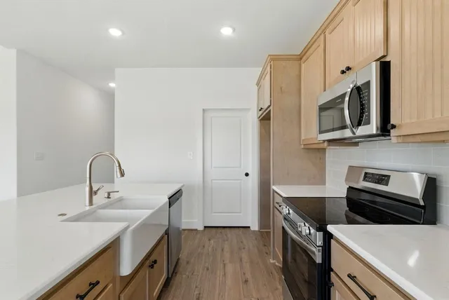 a kitchen with a sink a microwave a stove and refrigerator