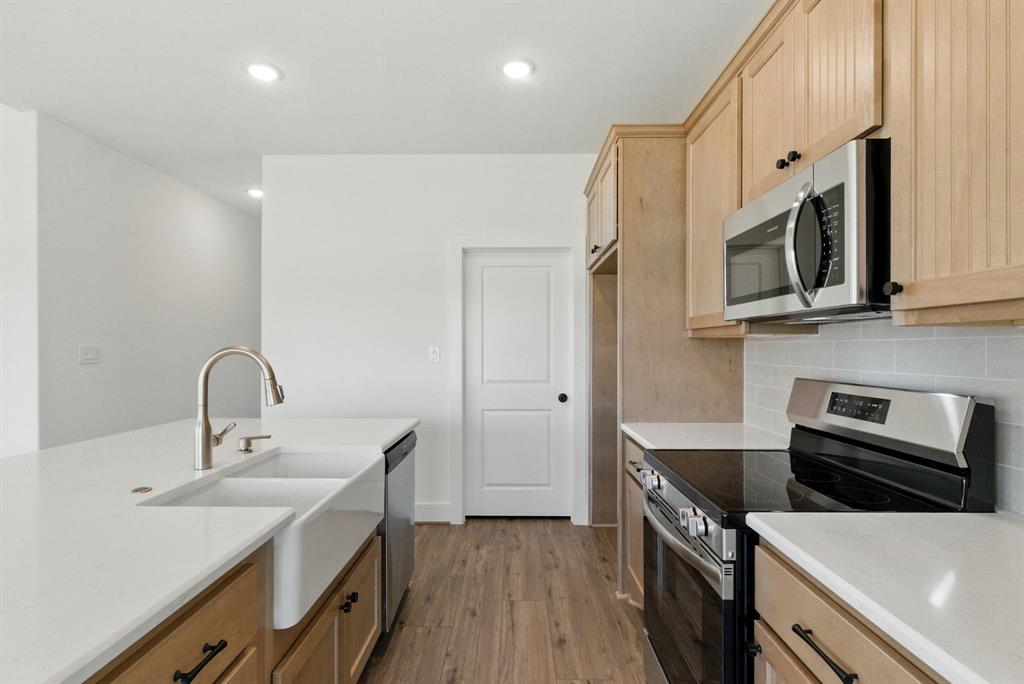 421 Jameson Springtown, TX 76082 - Photo 8 of 37 a kitchen with a sink a microwave a stove and refrigerator