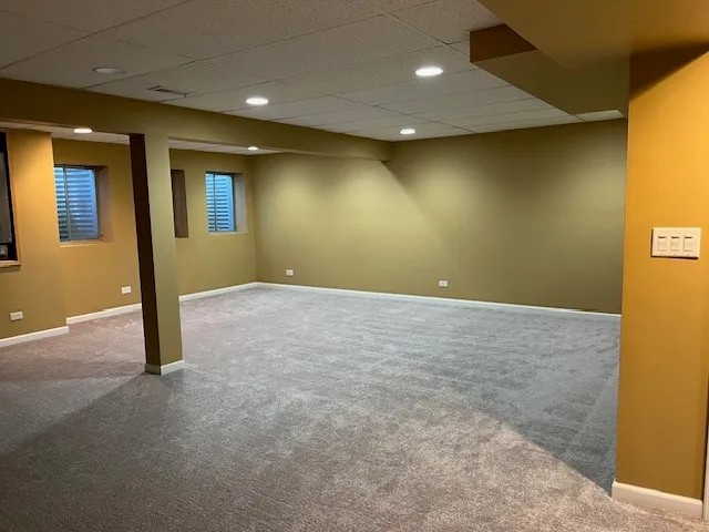 a view of an empty room with a window and bathroom