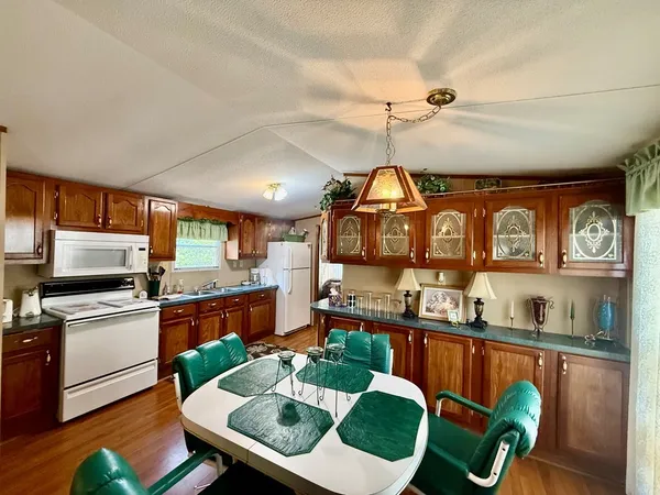a kitchen with stainless steel appliances granite countertop a stove a sink dishwasher and cabinets with wooden floor