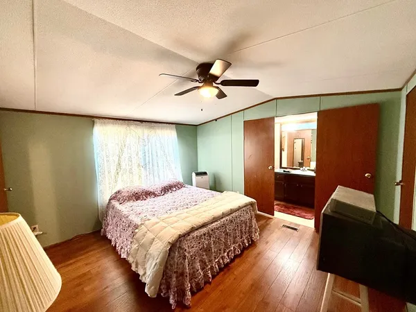 a bedroom with a bed and wooden floor