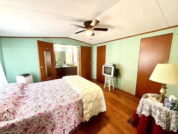 a bedroom with bed and wooden floor