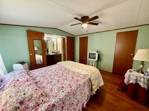 a bedroom with a large bed and wooden floor