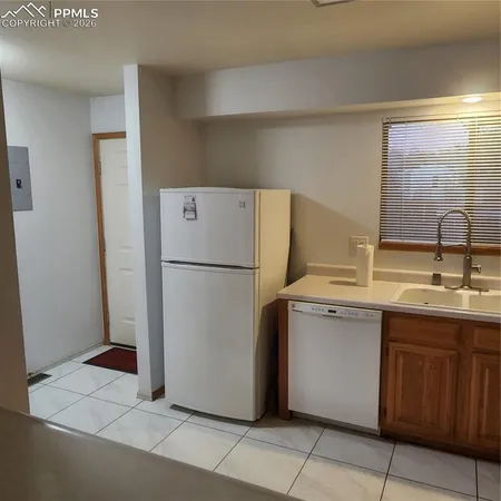 a kitchen with a sink refrigerator and cabinets