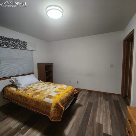 a bedroom with a bed and a wooden floor
