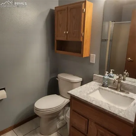 a bathroom with a granite countertop toilet sink and mirror