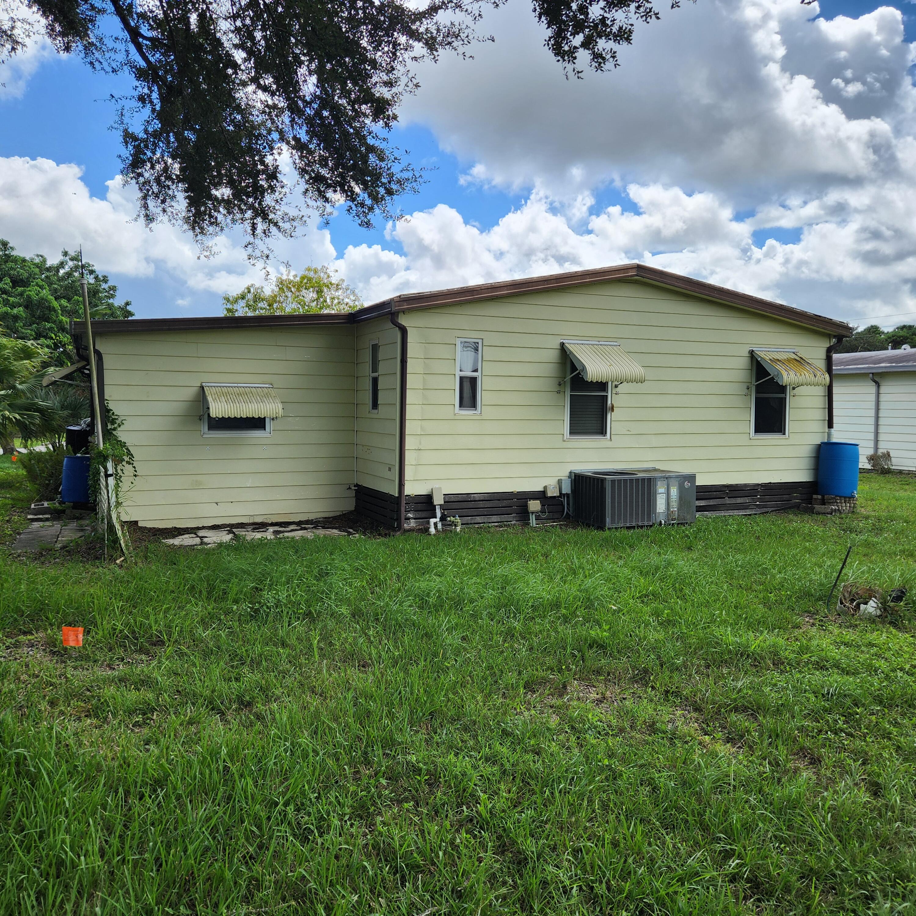 2847 Southwest Thunderbird Trail Stuart, FL 34997 - Photo 2 of 22 a backyard of a house with table and chairs