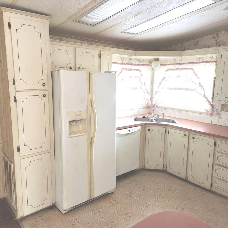 2847 Southwest Thunderbird Trail Stuart, FL 34997 - Photo 5 of 22 a white refrigerator freezer and a dishwasher in a kitchen
