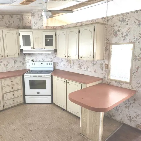 a kitchen with a stove a sink and a window