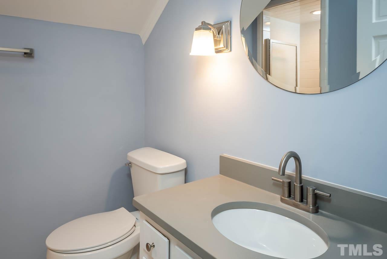 4008 Oak Park Road Raleigh, NC 27612 - Photo 18 of 24 a bathroom with a toilet a sink and mirror