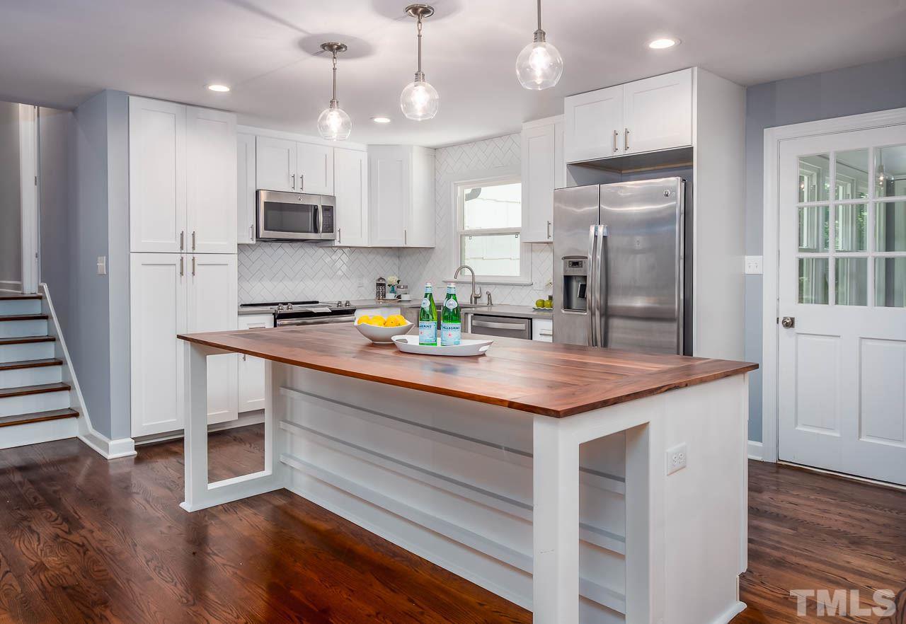 4008 Oak Park Road Raleigh, NC 27612 - Photo 3 of 24 a kitchen with stainless steel appliances granite countertop a refrigerator a sink dishwasher a stove and white cabinets with wooden floor
