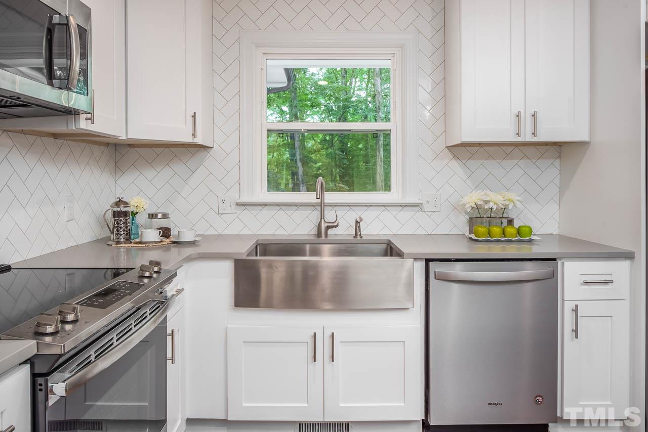 4008 Oak Park Road Raleigh, NC 27612 - Photo 4 of 24 a kitchen with stainless steel appliances granite countertop a sink stove and cabinets