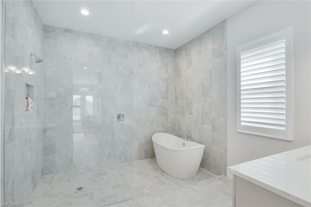 14327 Laguna Springs Lane Naples, FL 34114 - Photo 15 of 35 a spacious bathroom with a bathtub and shower