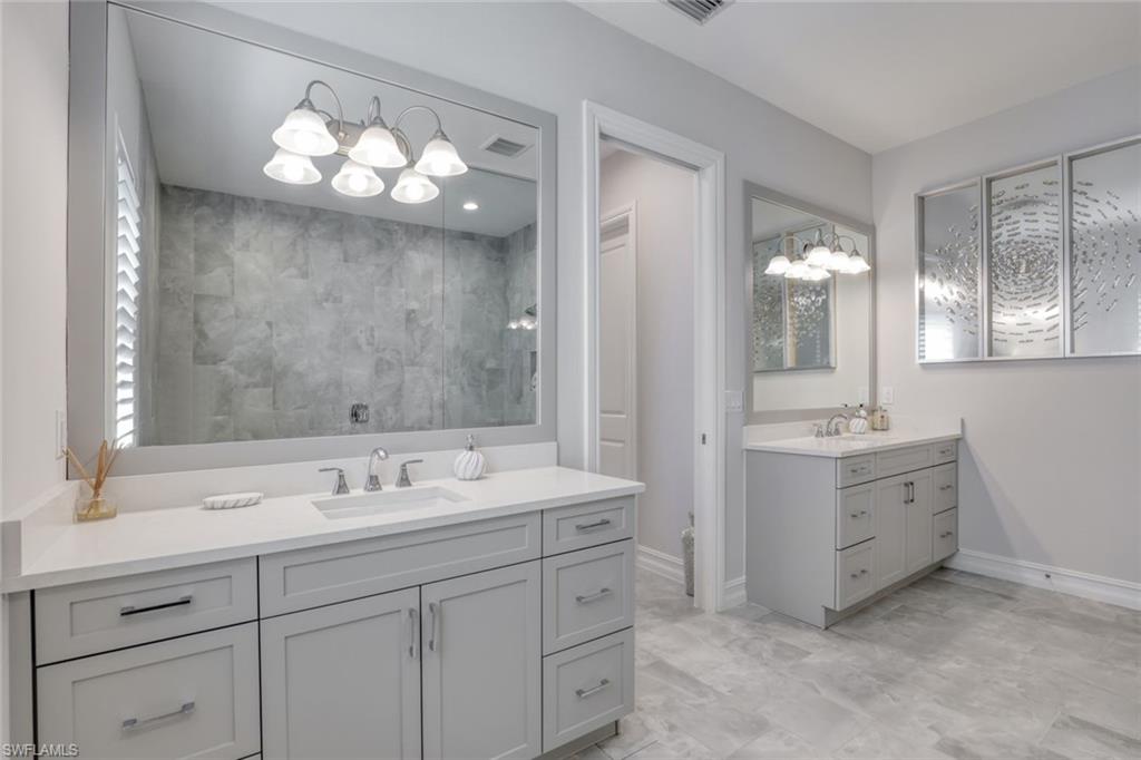 14327 Laguna Springs Lane Naples, FL 34114 - Photo 16 of 35 a bathroom with a sink vanity and mirror