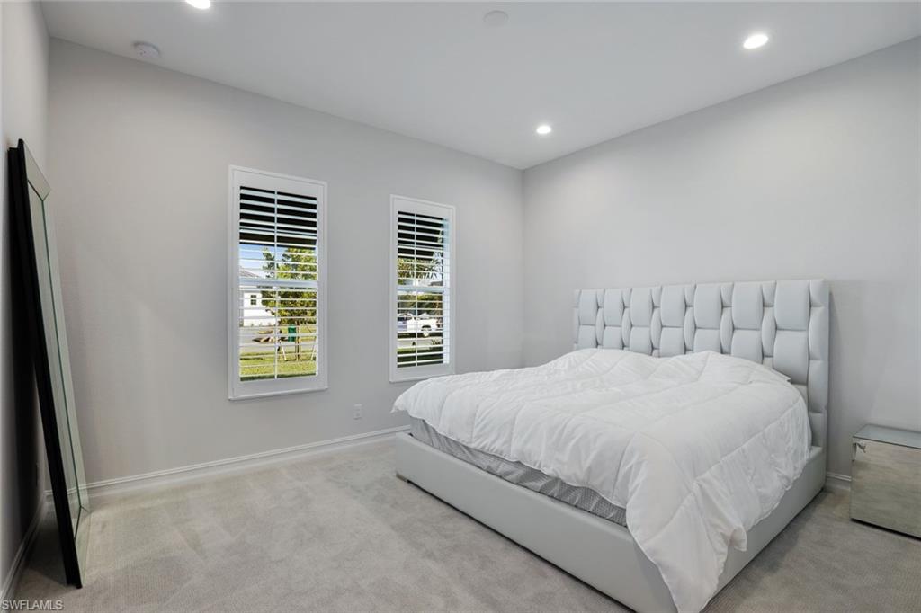 14327 Laguna Springs Lane Naples, FL 34114 - Photo 18 of 35 a large bed sitting in a bedroom next to a window