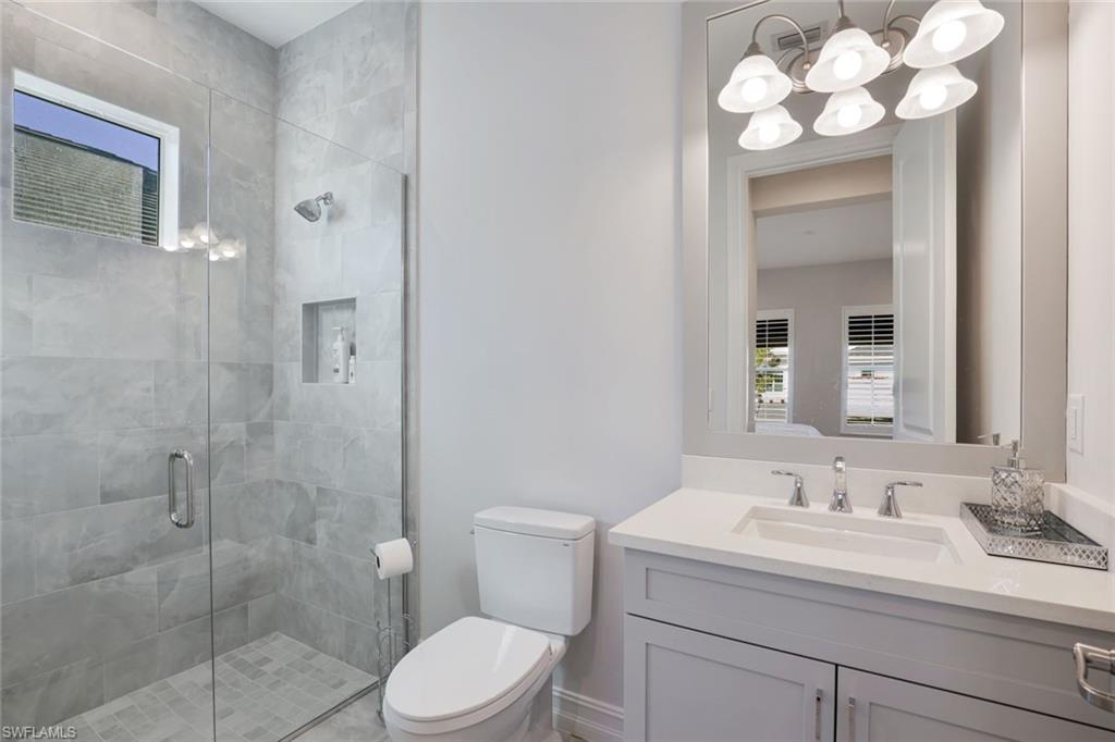 14327 Laguna Springs Lane Naples, FL 34114 - Photo 19 of 35 a bathroom with a sink vanity granite toilet and a mirror
