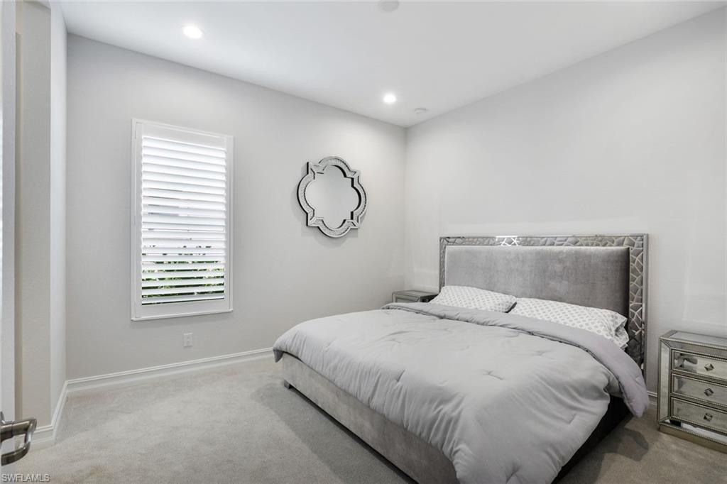 14327 Laguna Springs Lane Naples, FL 34114 - Photo 20 of 35 a large bed sitting in a bedroom next to a window