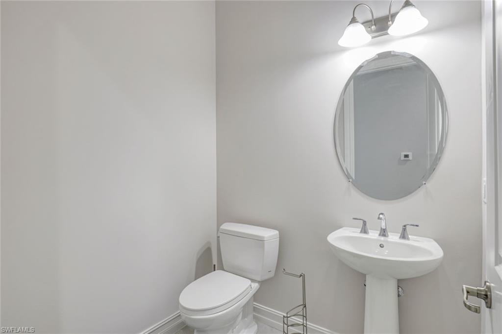 14327 Laguna Springs Lane Naples, FL 34114 - Photo 23 of 35 a bathroom with a toilet a sink and mirror