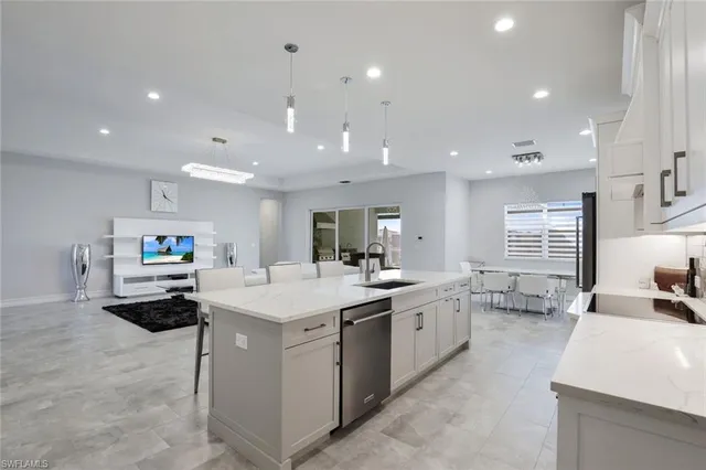 a large kitchen with kitchen island a sink table and chairs