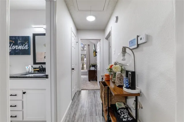 a view of a hallway with furniture and wooden floor