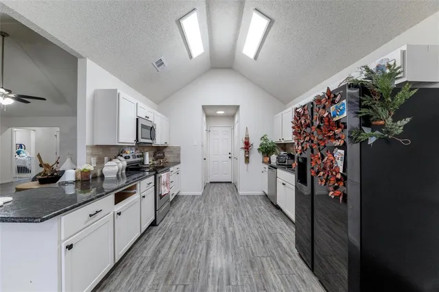 a large kitchen with a lot of white cabinets