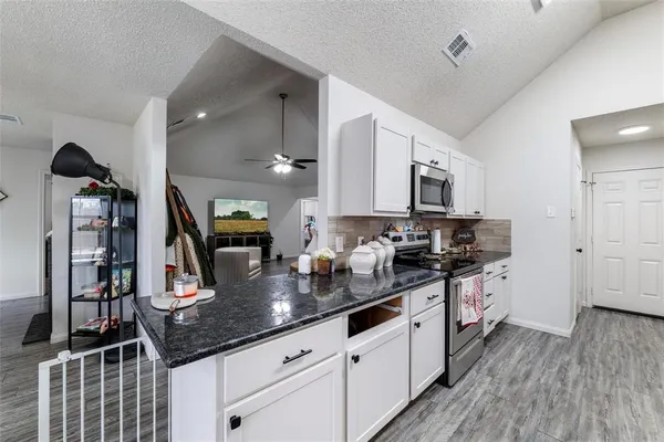 a kitchen with granite countertop a sink and cabinets