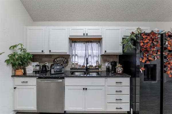 a kitchen with stainless steel appliances white cabinets and a sink
