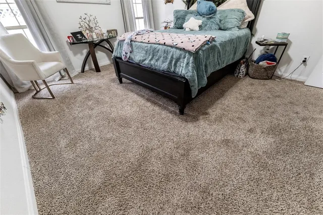 a bedroom with a bed window and a table in it