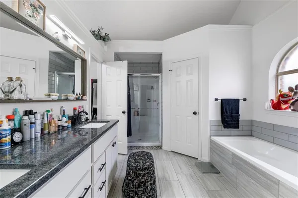 a large bathroom with a double vanity sink a mirror and a bathtub